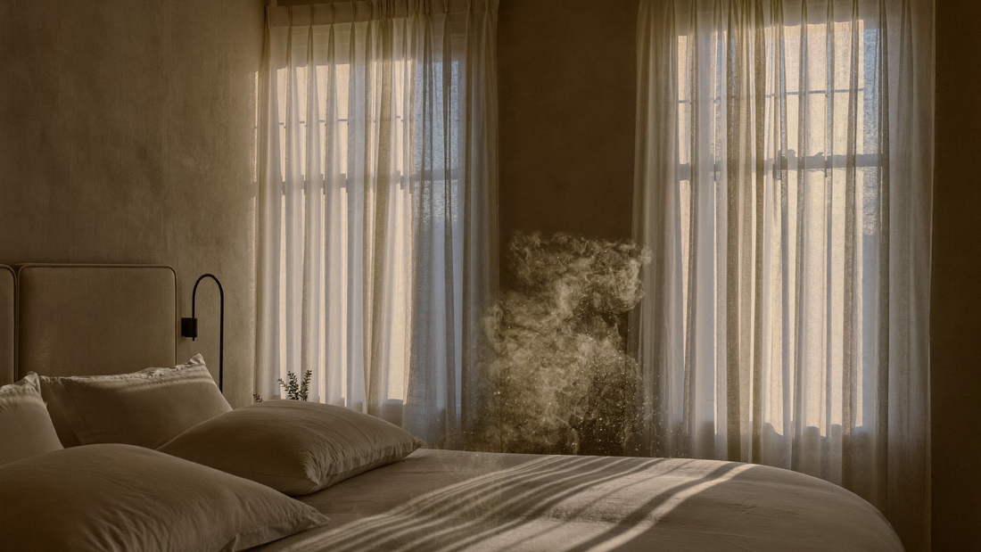 Lumière dorée du soir filtrant à travers les rideaux d'une chambre luxueuse, tons crème et ivoire, atmosphère apaisante et sereine évoquant la transition estivale vers l'automne