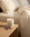 Bougie parfumée lavande en cire de soja Sleeping Zen sur une table de nuit en bois clair