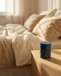 Bougie parfumée ambre en cire de soja bleu profond Sleeping Zen sur une table de nuit